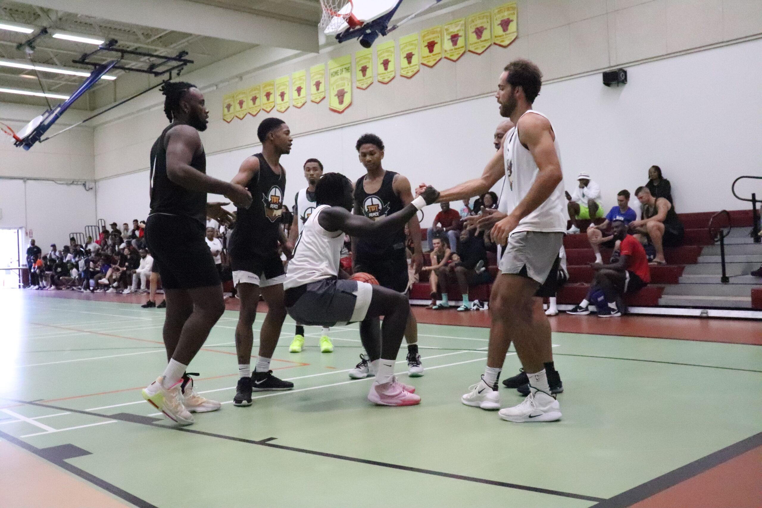 篮球运动员在一场篮球比赛中帮助他的队友站起来