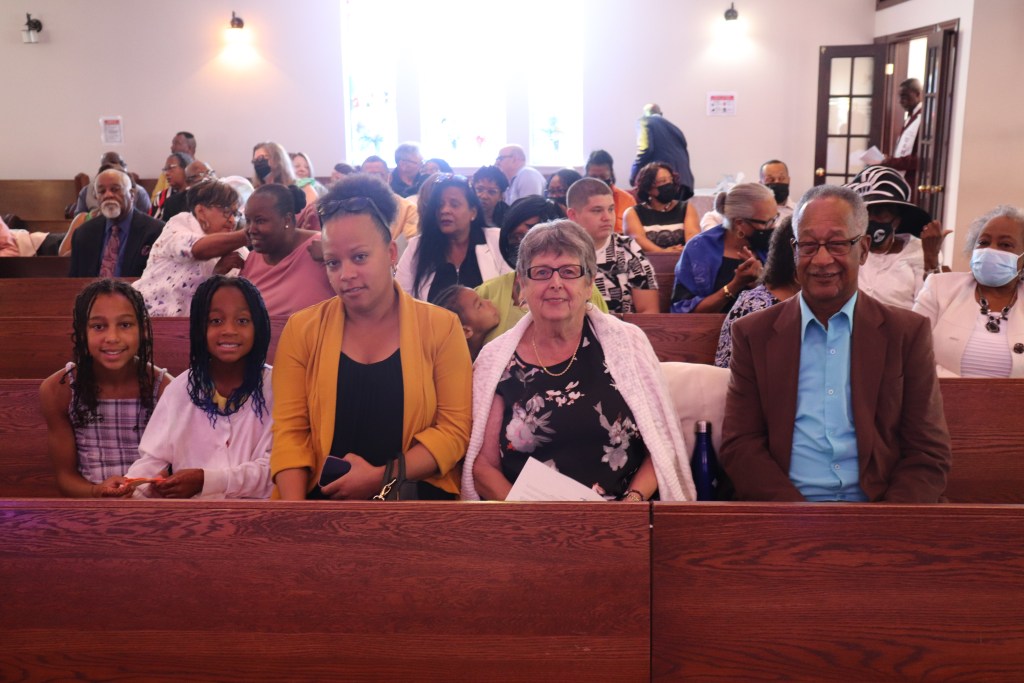 一个五口之家在教堂对着镜头微笑。