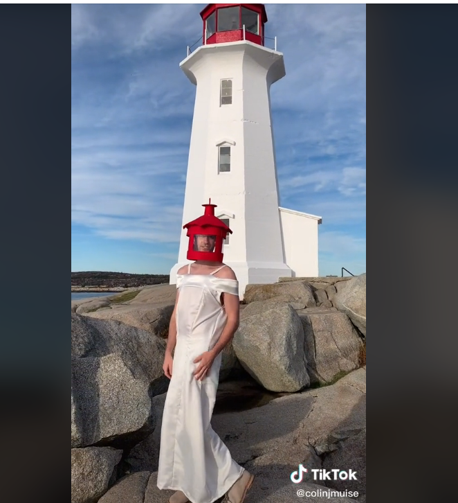 一个穿着白裙子，戴着红帽子，打扮成灯塔的男人