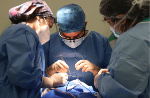 三名穿着工作服的医生/医疗专业人员进行手术。