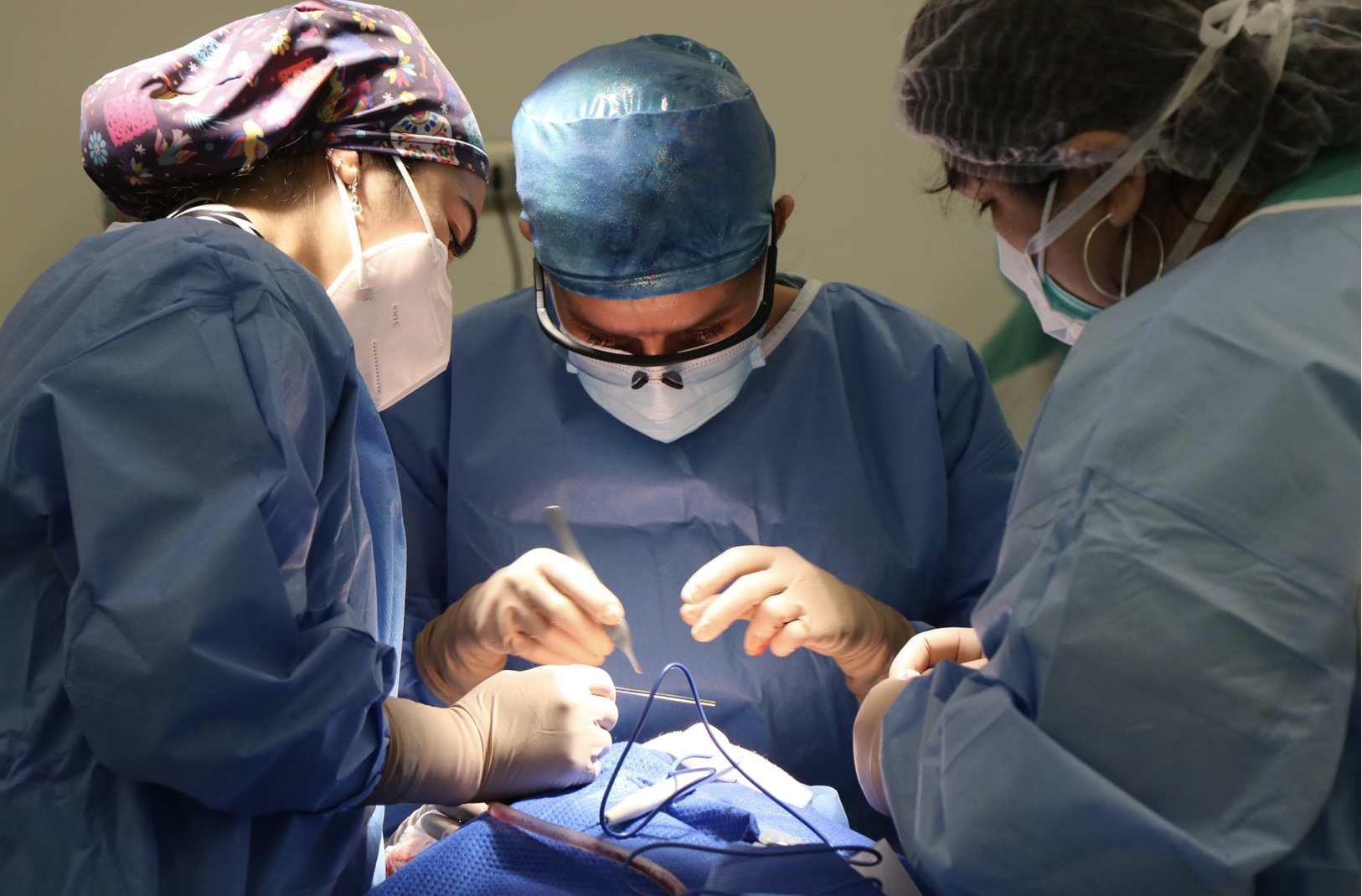 三名穿着工作服的医生/医疗专业人员进行手术。