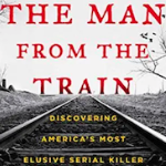 一本书的封面是一幅黑白照片，照片上是火车轨道和天空中写着红色字体的光秃秃的树木。