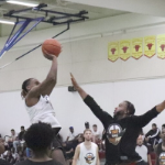 一名篮球运动员跳起来投篮，另一名运动员试图阻挡他