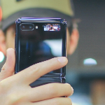 一个十几岁的男孩举起手机，挡住了我们的视线