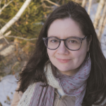 一个年轻的白种女人，留着黑色长发，戴着眼镜