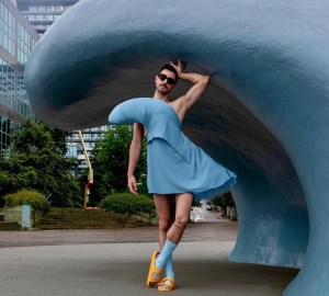 在哈利法克斯海滨，一名穿着波浪服装的男子站在波浪雕塑前。