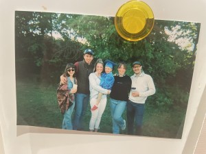 五个年轻人和一个穿着毕业礼服的小孩在树下合影