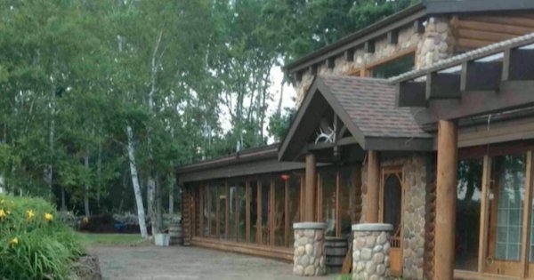 木石结构的建筑，后面有绿树