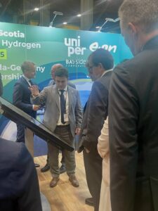 照片中央的EverWind公司首席执行官兼创始人特伦特·维奇(Trent Vichie)在与Uniper和意昂公司签署谅解备忘录的仪式上，似乎正在向其他男士解释展示板。(图片由EverWind提供)