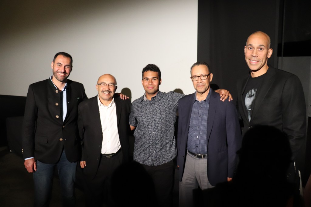 电影开场时，五个穿着西装和牛仔裤的男人微笑着站在一起