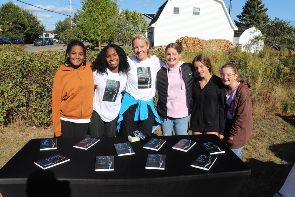 六个女孩在户外摊贩桌上卖《用我的眼睛写字》