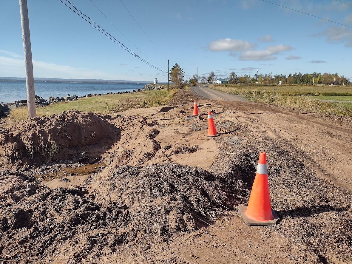 橙色的塔架坐落在一条乡村道路两旁，将道路上的洞与道路本身隔开