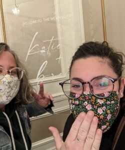 两名戴着彩色印花口罩的妇女挥舞着和平手势